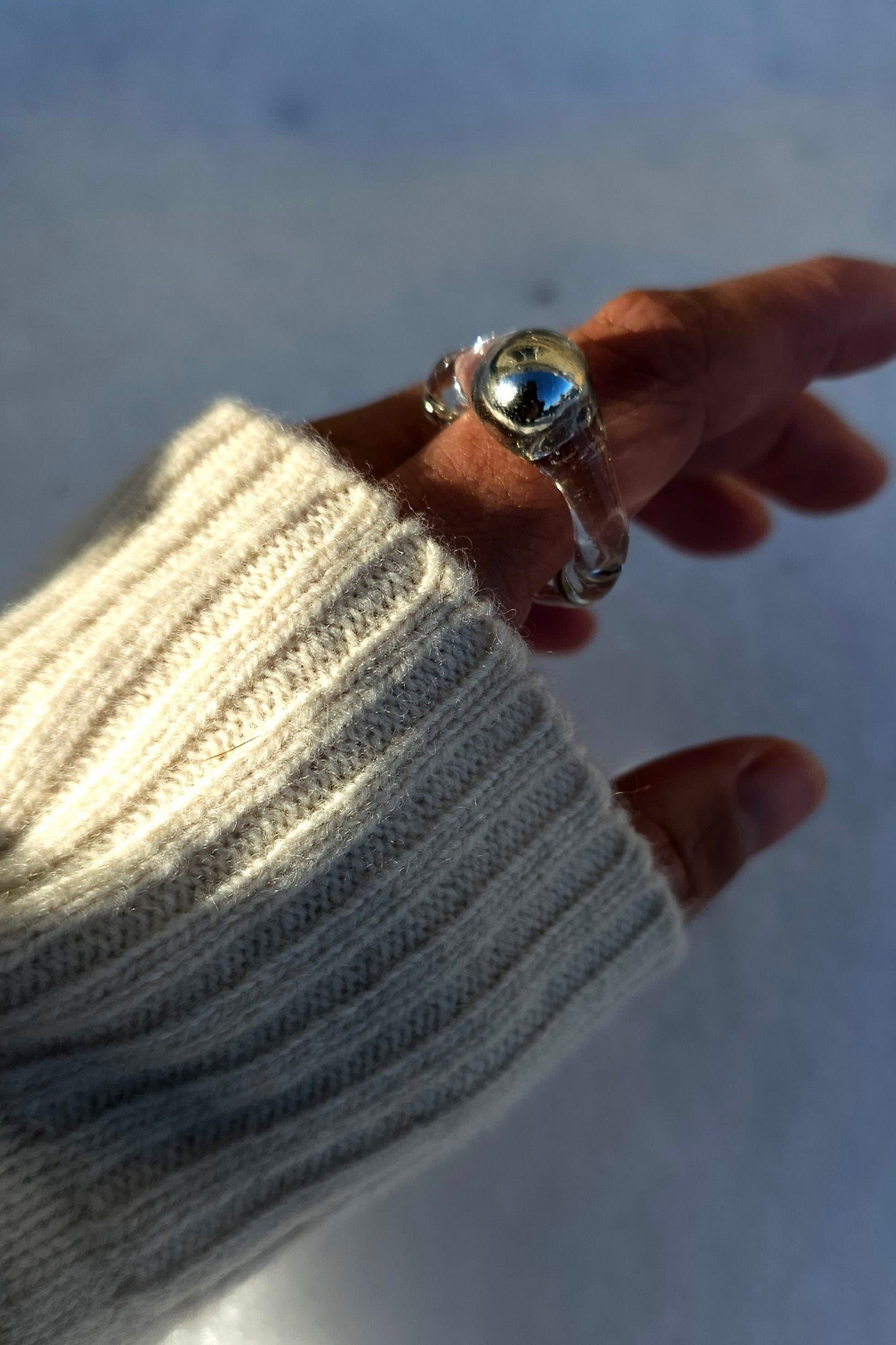 Model wearing MITSUKI silver ring, featring a clear band with silver orb in the center