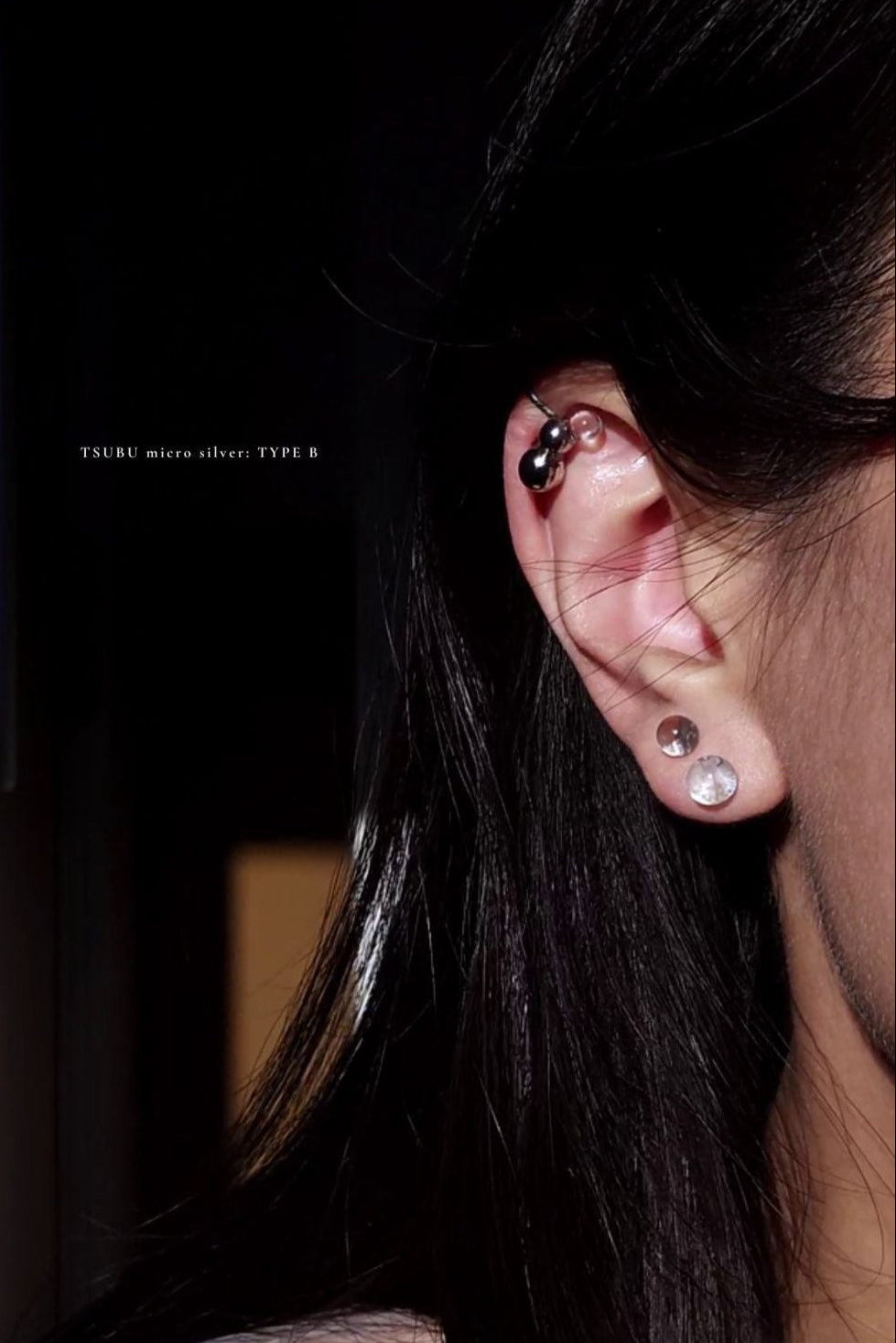 Model wearing TSUBU micro silver type A worn upside down on the helix