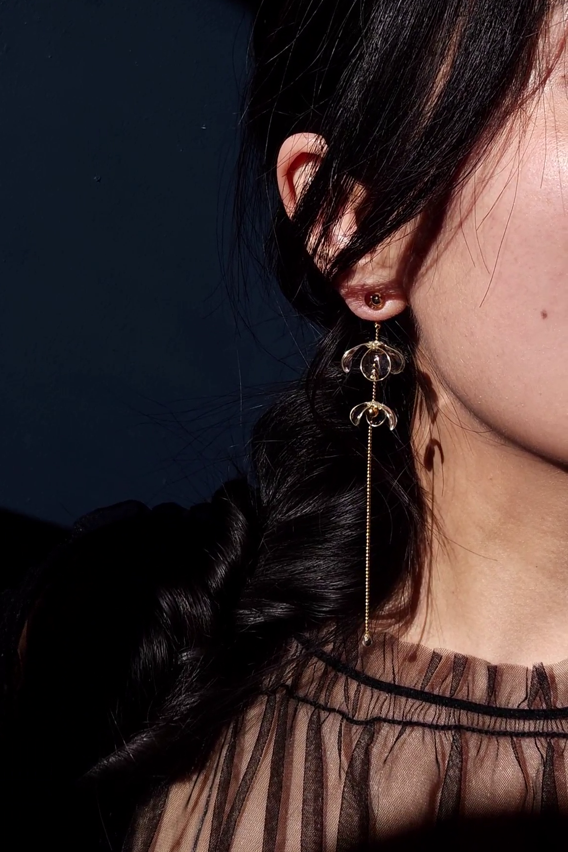 Model wearing clear floral earring with gold accent, MEIKA gold long drop