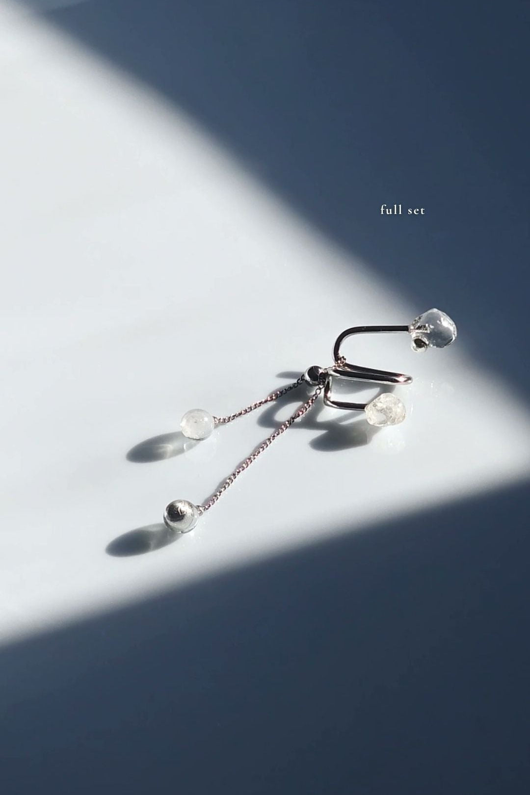 REI multiway ear cuff and ring set shown detached with adjustable chain, clear and melting ice stones, and slide ball for customizable styling.