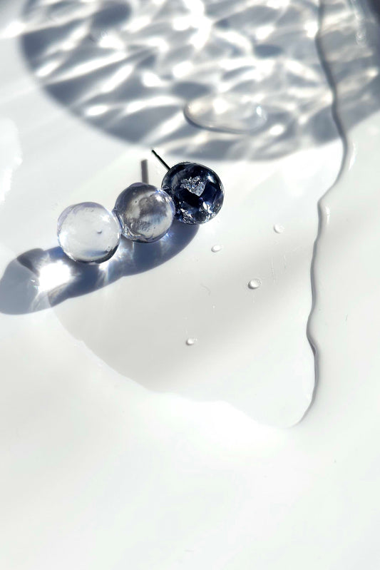 Close-up of SORA vertical orb earrings showing gradient blue hues. Each orb is uniquely handcrafted.
