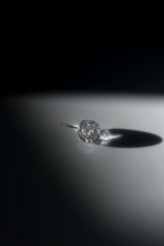 SUIKO stud earring inspired by shimmering water reflections, minimalist and captivating in soft silver and luminous clear tones.