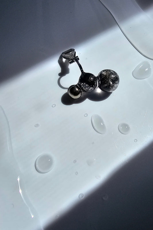 TSUBU mini black ear cuff features a hand-blended black orbs and a silver orb. Each piece is handcrafted. No piercing required. Wear it as a climber or an ear cuff.