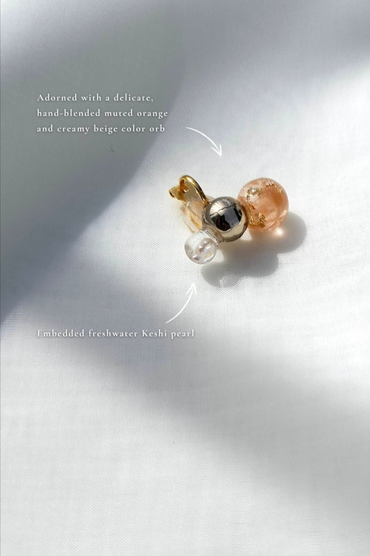 Description of the TSUBU mini orange ear cuff features a hand-blended beige orange orb with freshwater pearl and champagne gold orb. No piercing required.