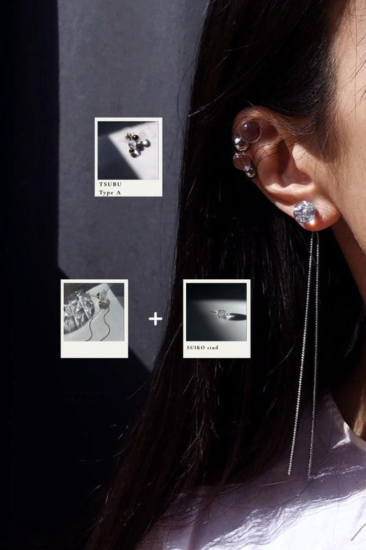 Model wearing clear and silver earring pieces, SUIKO stud with the chain from KAKERA multiway drop on earlobe, and TSUBU on helix.