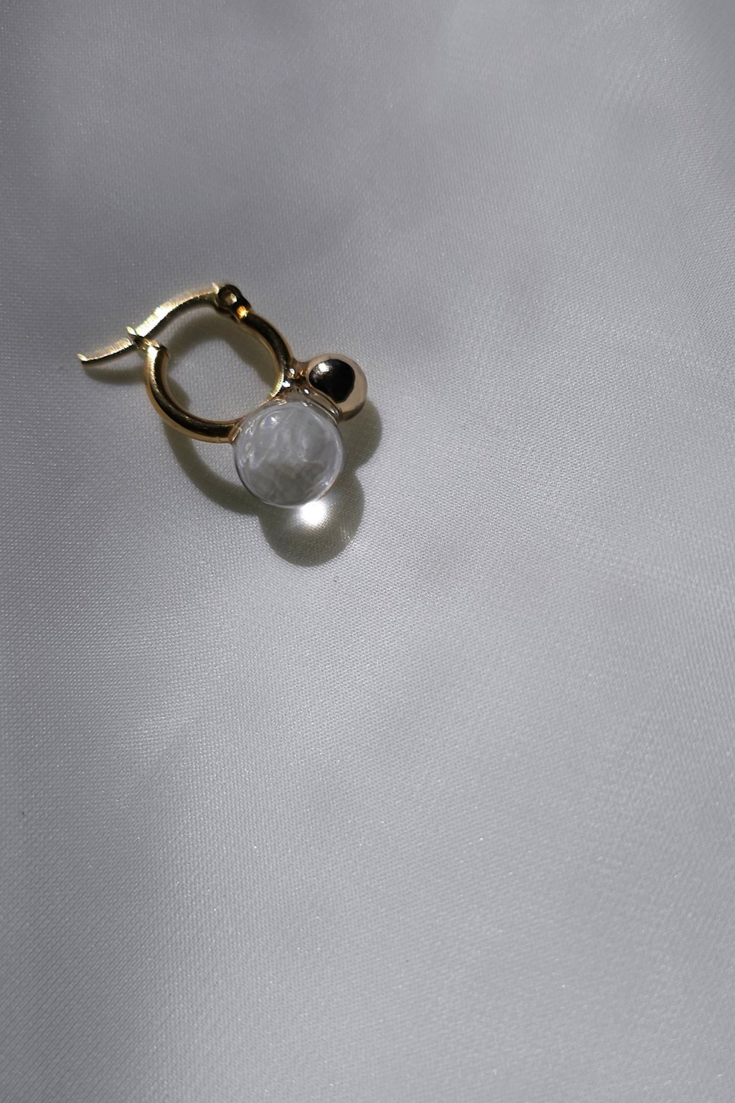YOTSUYU gold earrings with clear orb, handcrafted to echo night dew with a soft golden shimmer and airy elegance.