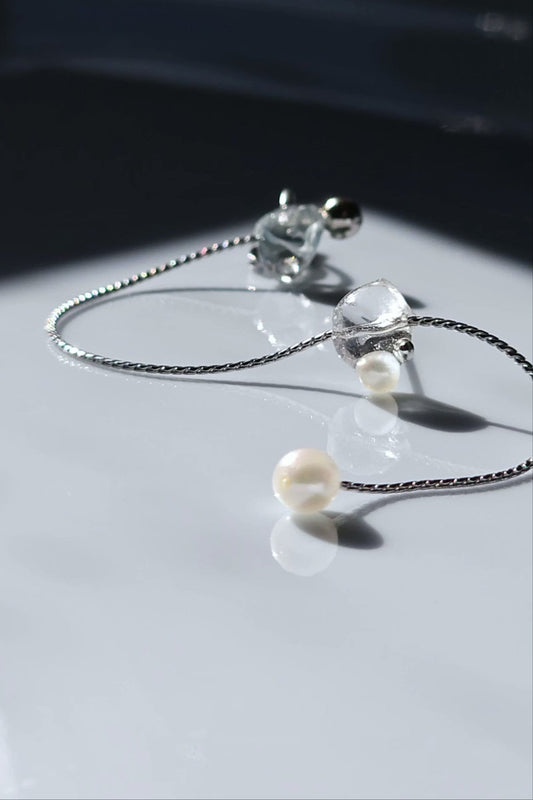 NAMI multiway ear cuff and stud connected by chain with freshwater pearls, featuring hand-blended silvery-blue and gray tones inspired by ocean waves.