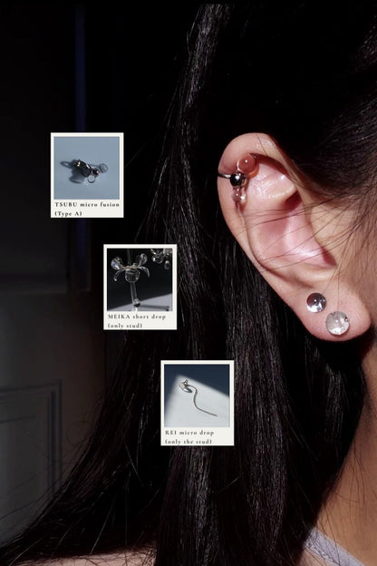 Model wearing TSUBU micro orb earcuff on the helix with studs from MEIKA floral short drop and REI silver icy drop
