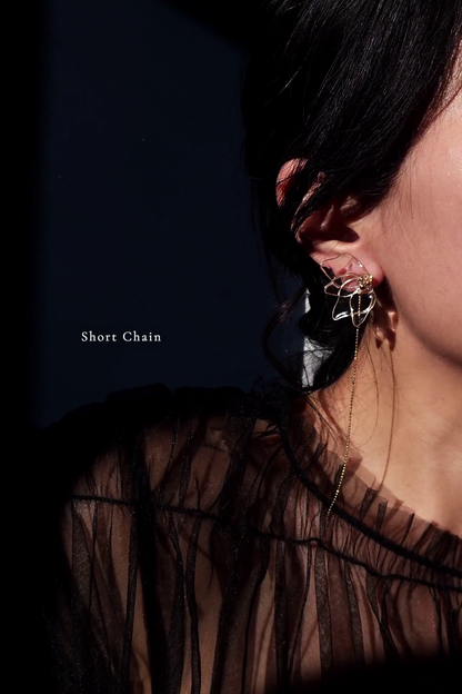 Model wearing clear floral earring in gold, MEIKA gold chain drop, with a single shorter chain.