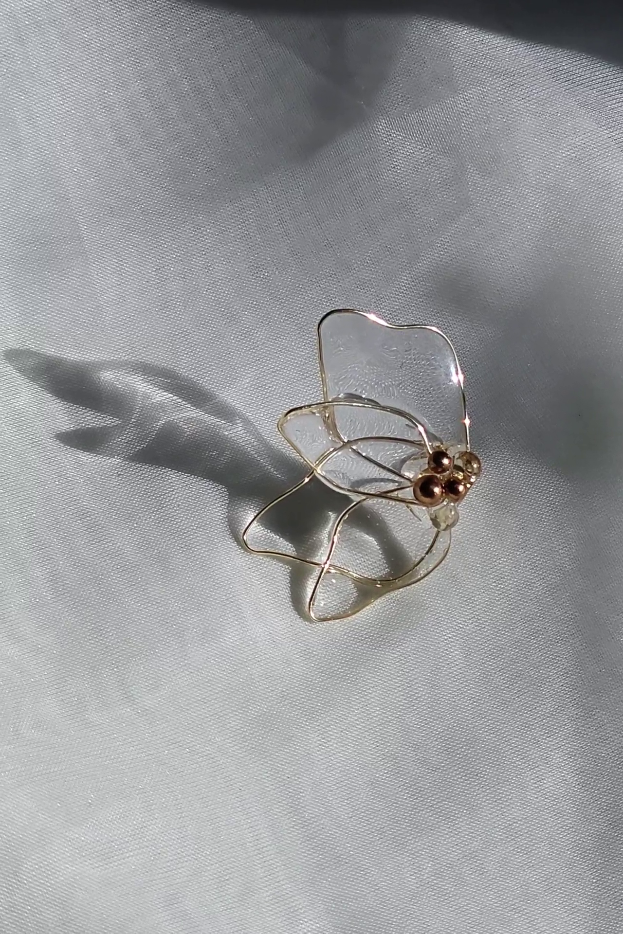 the flower stud part from MEIKA gold chain drop on a flat surface