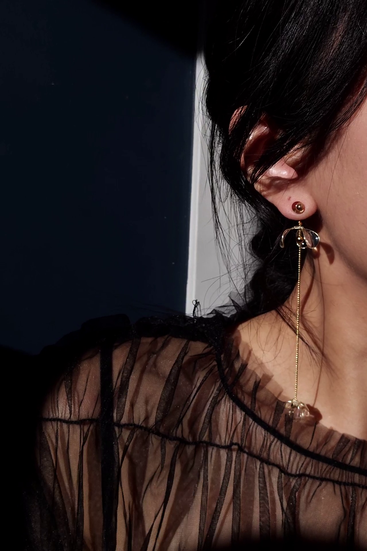 Model wearing clear flower drop with gold accent. MEIKA gold long drop, with flowered set apart.