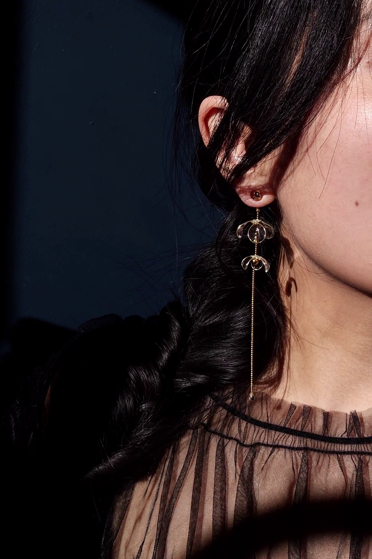 Model wearing clear floral earring with gold accent, MEIKA gold long drop