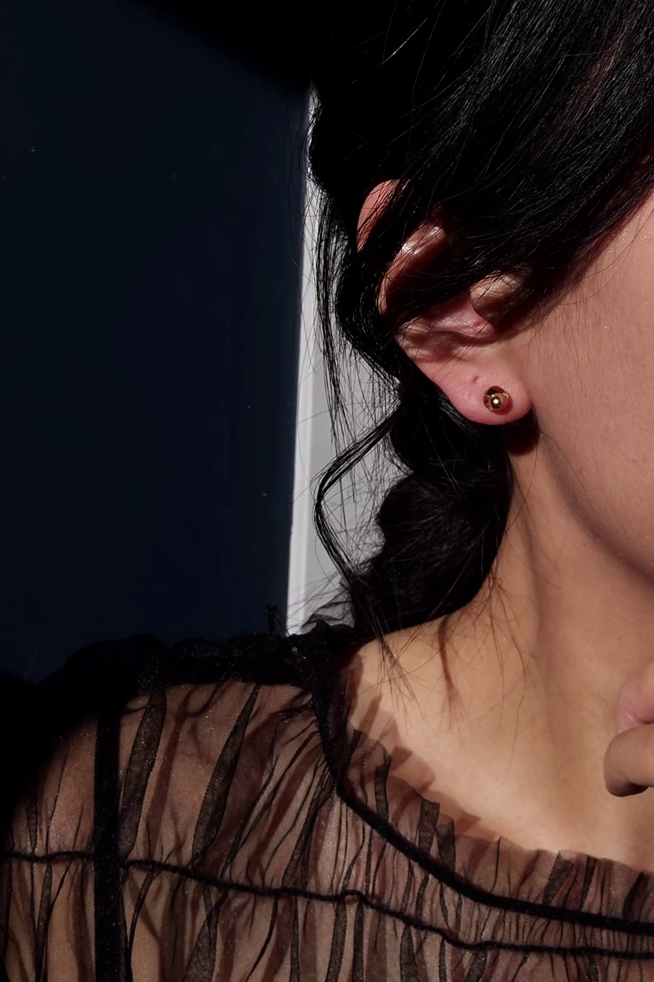 Model wearing 6mm stud with floating golden orb inside from clear flower drop, MEIKA gold long drop.