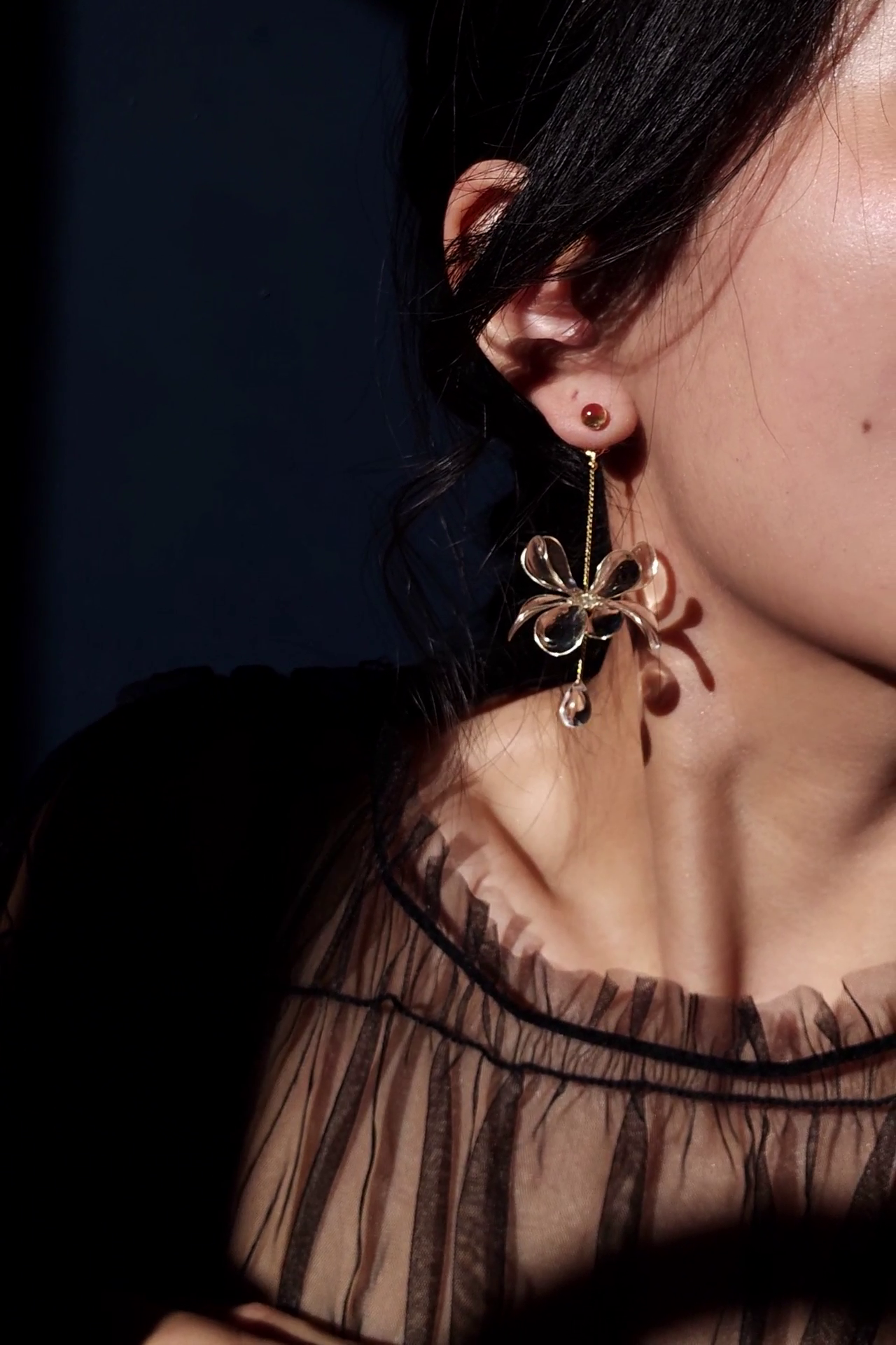 Model wearing clear flower drop earring with gold accent, MEIKA gold short drop.