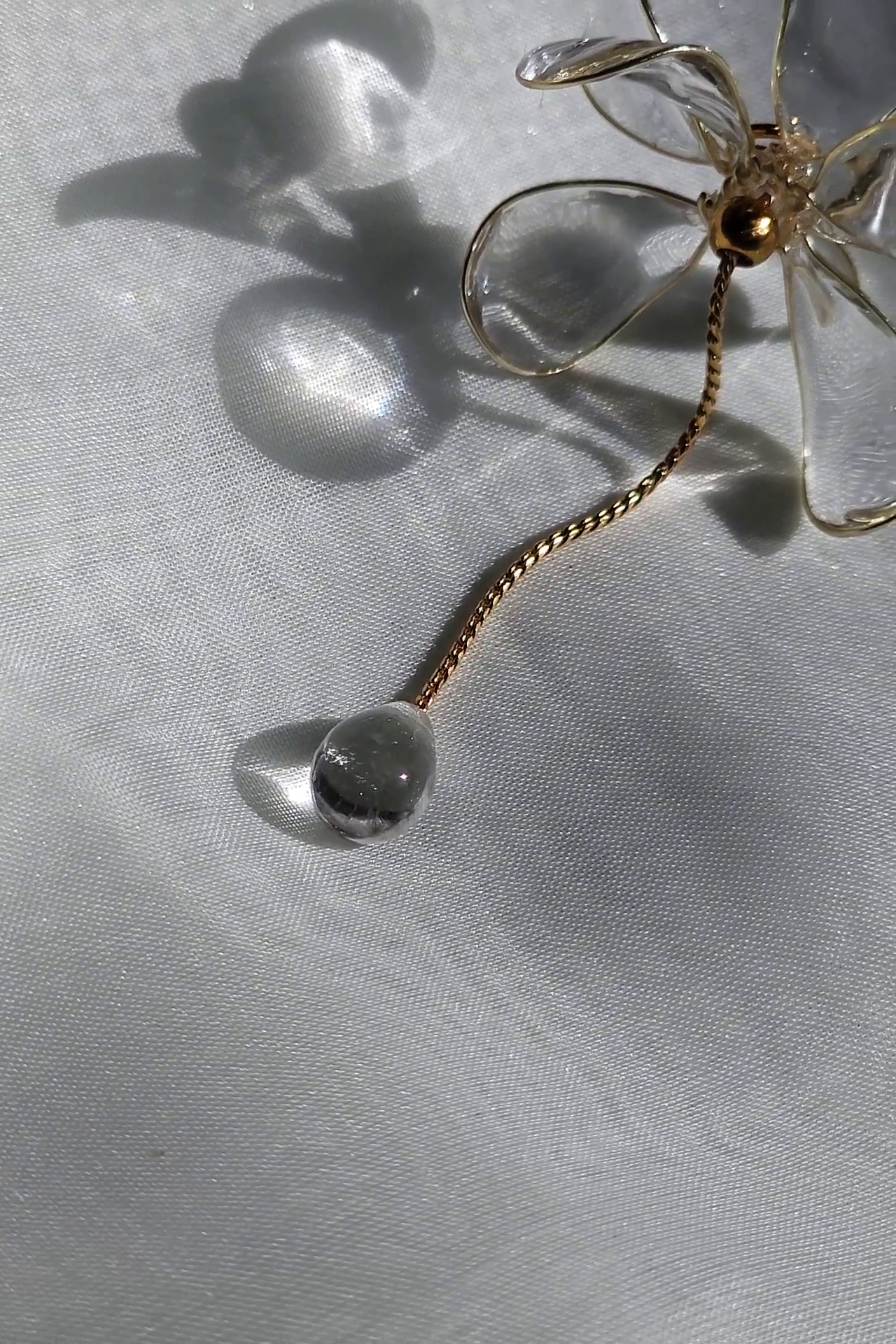 Close-up picture of the teardrop motif at the end of floral drop chain earring, MEIKA gold short drop.
