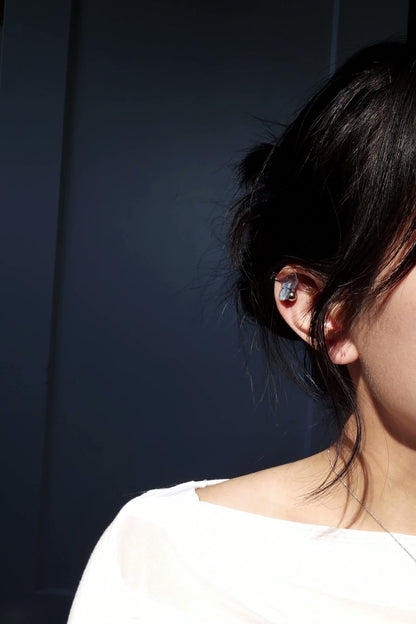 Model wearing NAMI ear climber on helix, elegant silvery blue-gray stone with silver orb.