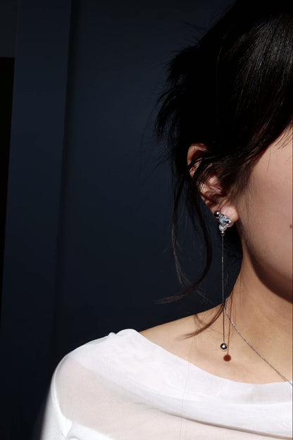 Model wearing NAMI multiway drop earring showcasing detachable chain, freshwater pearl, and fluid silvery-blue glow