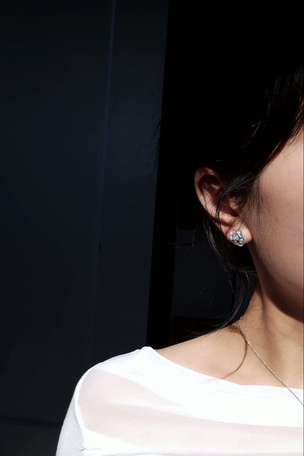 Model wearing only the stud part do NAMI short drop stud with freshwater pearls.