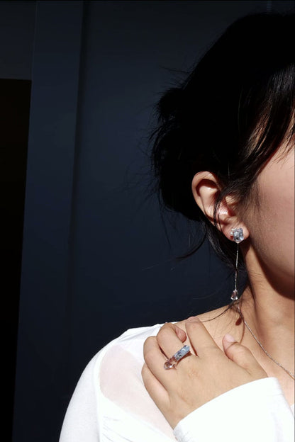 Model wearing NAMI short drop stud with freshwater pearls and clear stone chain, crafted in signature silvery-blue wave-inspired tones.