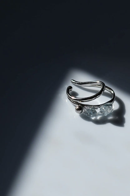 NAMI silver teardrop ear cuff with two silvery blue-gray hand-molded stones and tiny silver orb, wave-inspired design.