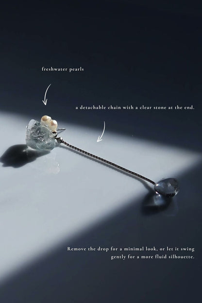Flatlay of NAMI multiway short drop earring with pearls, silvery-blue stone, and removable chain for minimal or fluid styling.