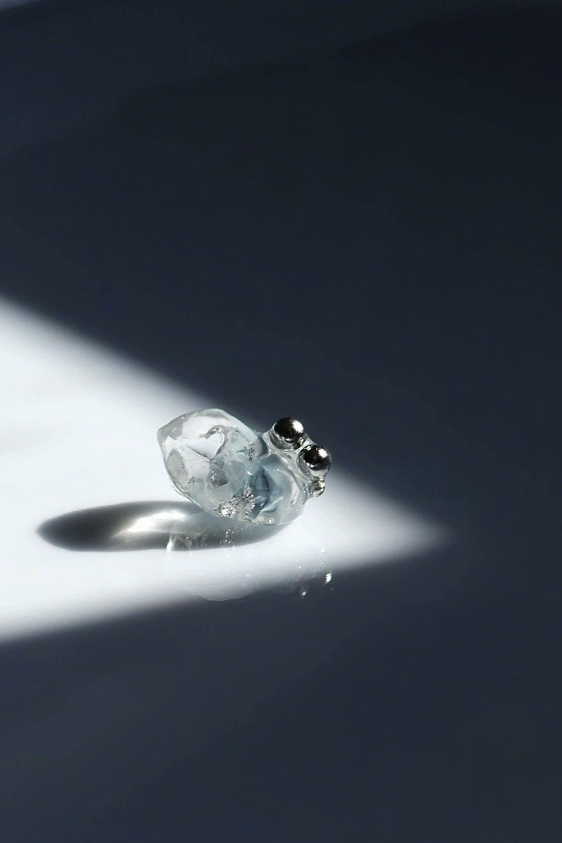 NAMI stud earring with silvery-blue hand-molded stone and three tiny silver orbs, inspired by ocean waves, shown alone for a minimal look.