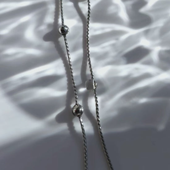 A video of the HISEN silver multiway drop earring with clear orb and silver chain strands, versatile as stud, drop, or dramatic style.