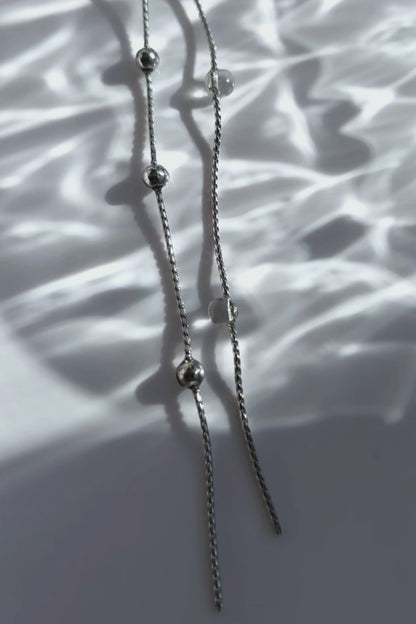A video of the HISEN silver multiway drop earring with clear orb and silver chain strands, versatile as stud, drop, or dramatic style.