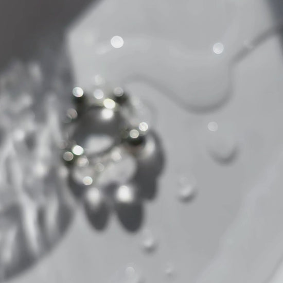 Close-up video of GINRO hoop earring showing clear and silver orbs in quiet, balanced design inspired by shimmering frozen dew.