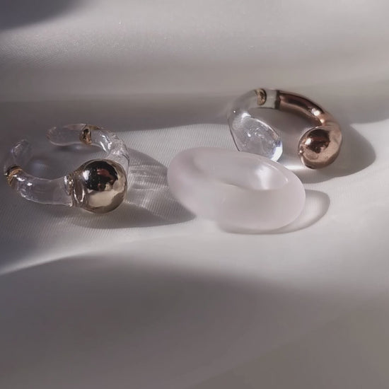 Model showcasing how to stack 3 rings in different variations - MITSUKi gold orb ring, TORORI gold sculptural ring and KIRI frosty ring.