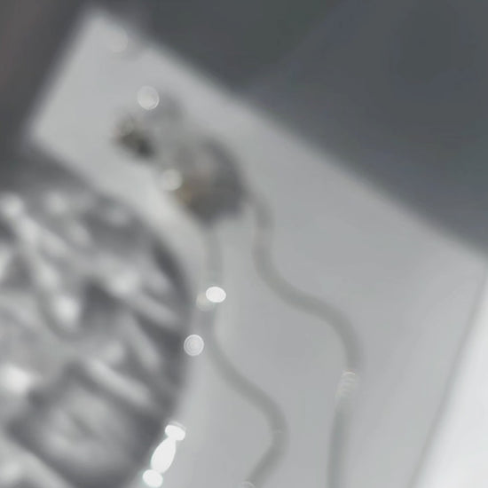 A video of the KAKERA drop earring inspired by natural rock fragments, with clear stud with freashwater pearl on delicate chain.