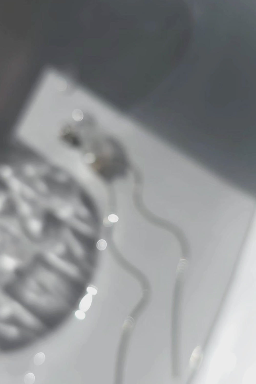 A video of the KAKERA drop earring inspired by natural rock fragments, with clear stud with freashwater pearl on delicate chain.