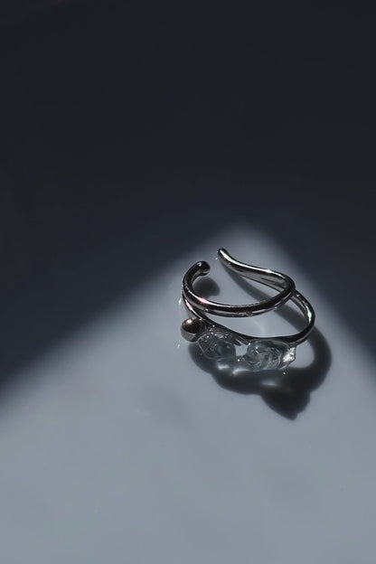 close-up video of the NAMI silver teardrop ear cuff with two silvery blue-gray hand-molded stones and tiny silver orb, wave-inspired design.
