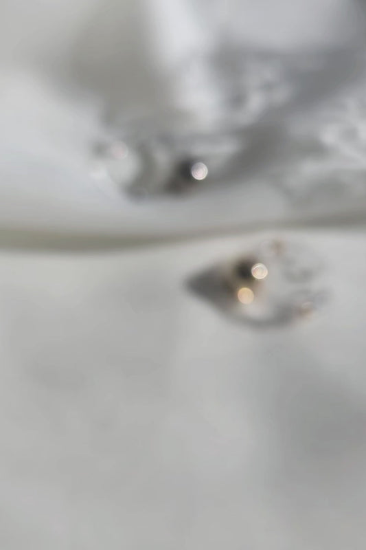 A video showcasing MITSUKI ring, silver orb ring with clear band, and MITSUKII ring, gold orb ring with clear band, on a flat surface.