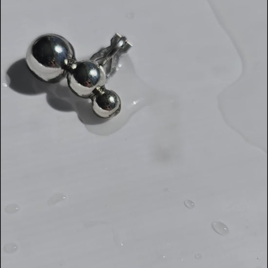 A close-up video of the TSUBU mini silber climber features 3 different sizes of orbs. It fits the curve of our ear. No piercing holes required.