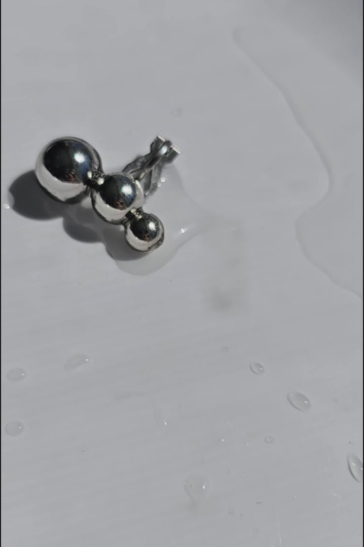 A close-up video of the TSUBU mini silber climber features 3 different sizes of orbs. It fits the curve of our ear. No piercing holes required.