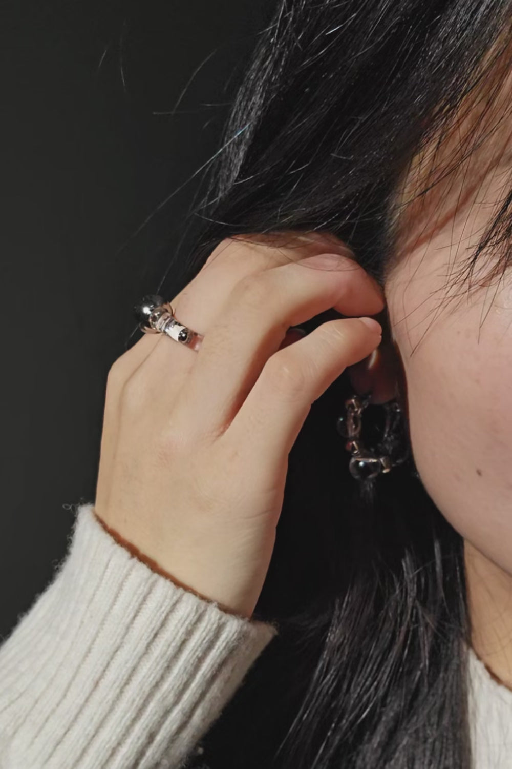 A video of a model wearing GINRO earring with silver orb facing front, styled with RYU reversible ear cuff.