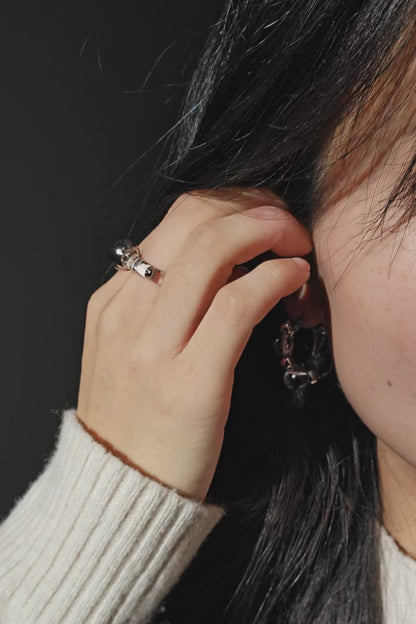 A video of a model wearing GINRO earring with silver orb facing front, styled with RYU reversible ear cuff.