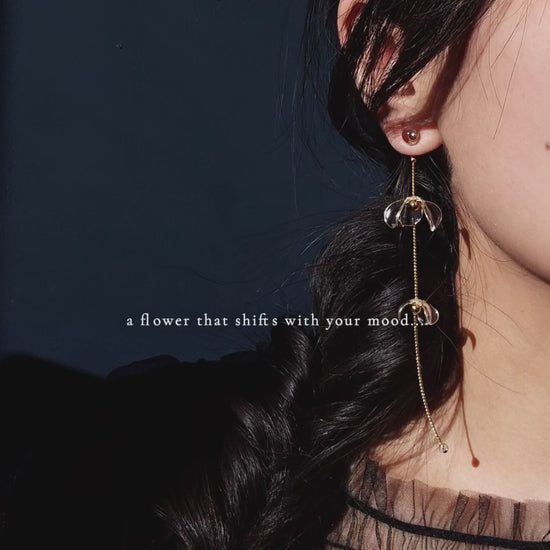 Model showcasing how clear floral drop, MEIKA gold long drop, works by sliding flowers in the video.