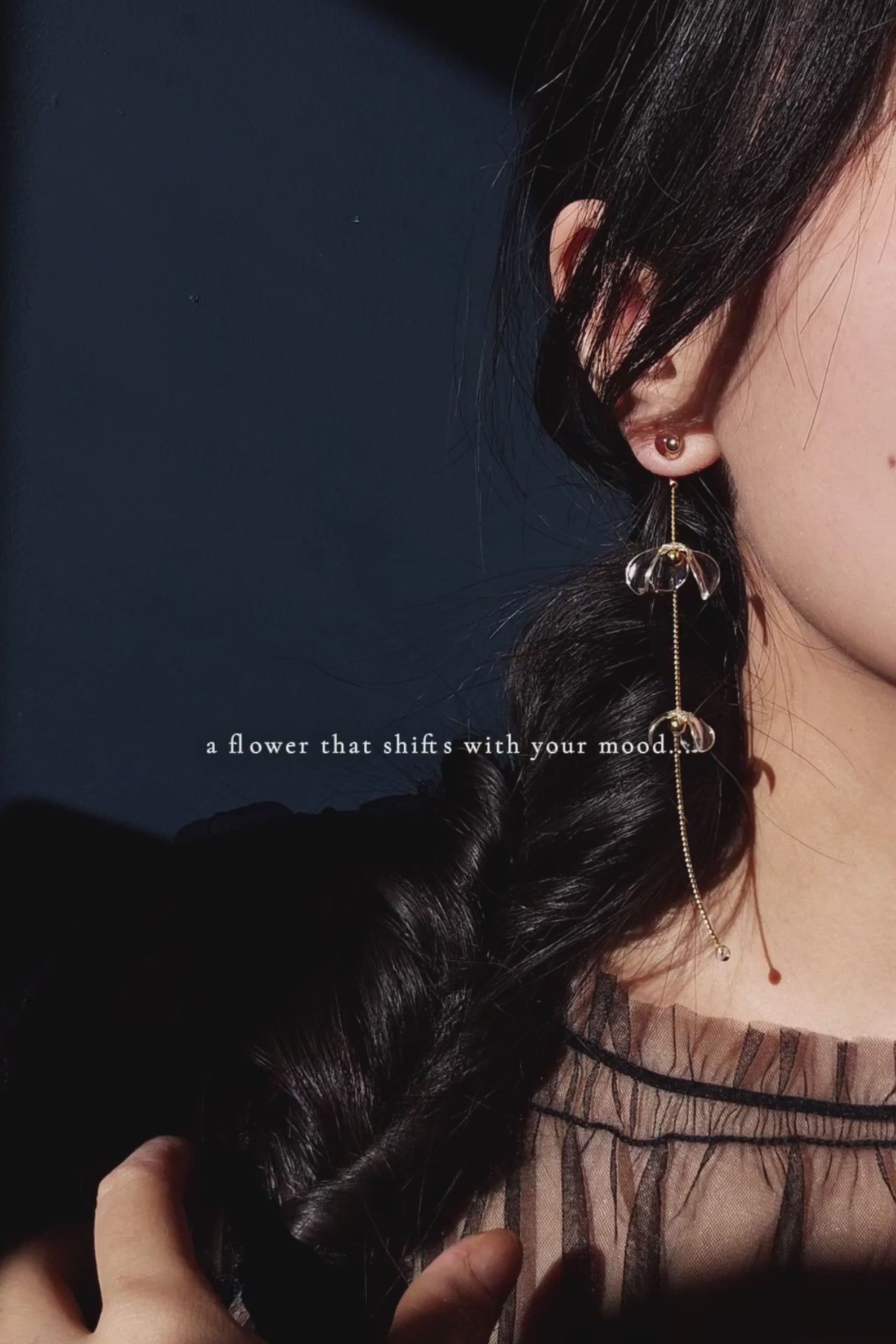 Model showcasing how clear floral drop, MEIKA gold long drop, works by sliding flowers in the video.