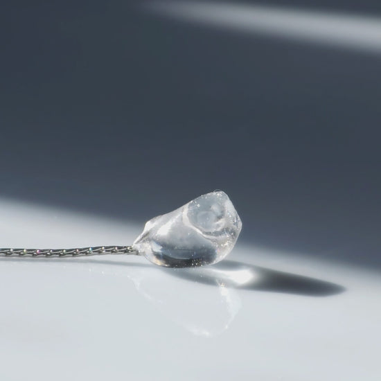 Video of flatlay of NAMI multiway short drop earring with pearls, silvery-blue stone, and removable chain for minimal or fluid styling.