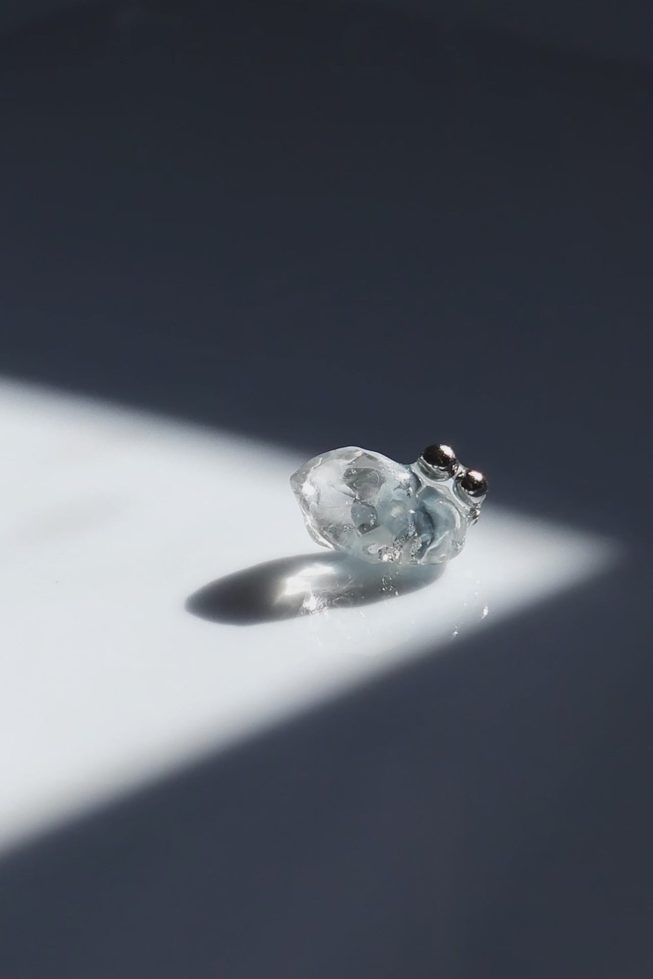 Video fo NAMI stud earring with silvery-blue hand-molded stone and three tiny silver orbs, inspired by ocean waves, shown alone for a minimal look.