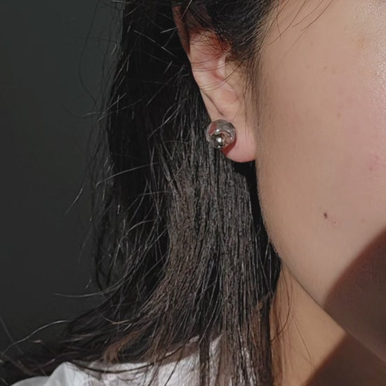 TSUYU silver stud earring on model, inspired by morning dew, with reflective clear and silver tones that shift with light.