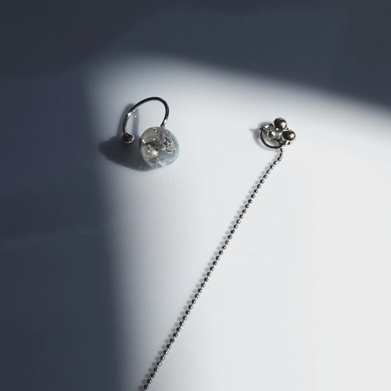 Close-up video of NAMI multiway chain ear cuff with hand-molded silvery-blue stone and detachable chain, inspired by ocean waves, sculptural yet delicate.