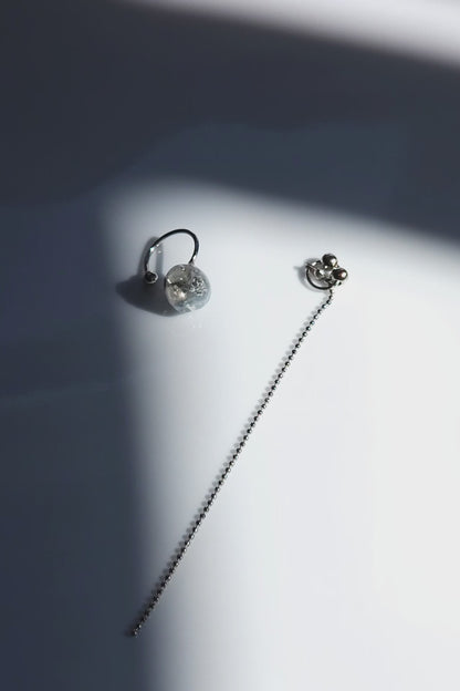 Close-up video of NAMI multiway chain ear cuff with hand-molded silvery-blue stone and detachable chain, inspired by ocean waves, sculptural yet delicate.