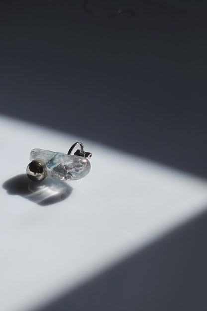 Close-up video of the NAMI ear climber with hand-molded silvery blue-gray stone and silver orb, inspired by waves.