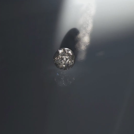 A video of the SUIKO stud earring inspired by shimmering water reflections, minimalist and captivating in soft silver and luminous clear tones.