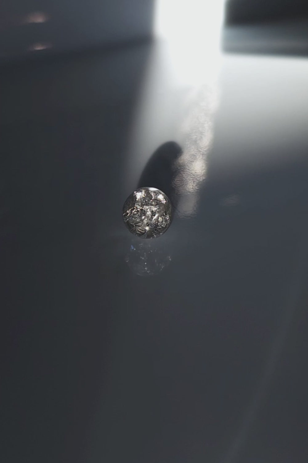 A video of the SUIKO stud earring inspired by shimmering water reflections, minimalist and captivating in soft silver and luminous clear tones.