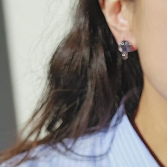 The video of a model wearing SORA short drop earring, only the stud part. The hand-blended blue orb changes color with the light.