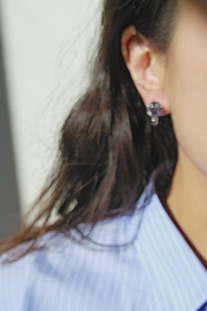 The video of a model wearing SORA short drop earring, only the stud part. The hand-blended blue orb changes color with the light.